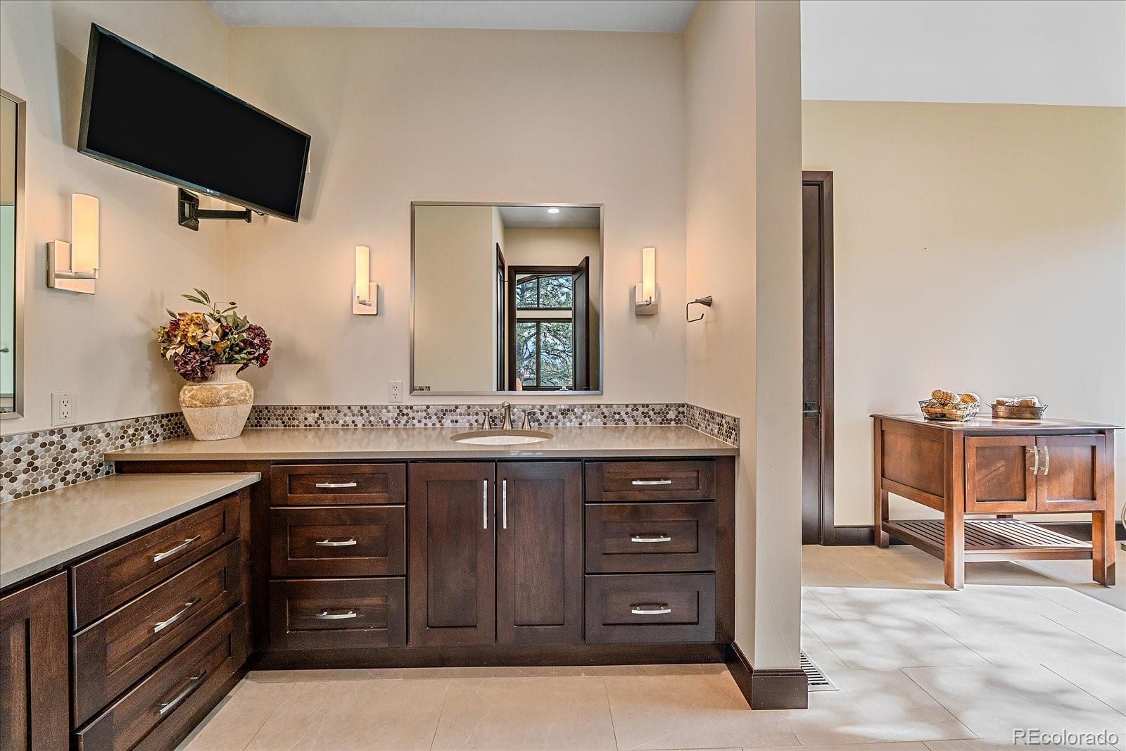 4331 Hilltop Road Evergreen, CO 80439 - Photo 17 of 45 a spacious bathroom with a granite countertop sink and a mirror