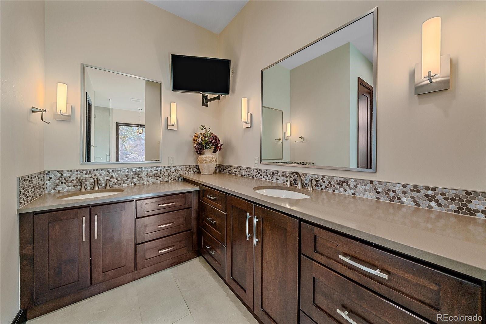 4331 Hilltop Road Evergreen, CO 80439 - Photo 18 of 45 a bathroom with a granite countertop sink and a mirror