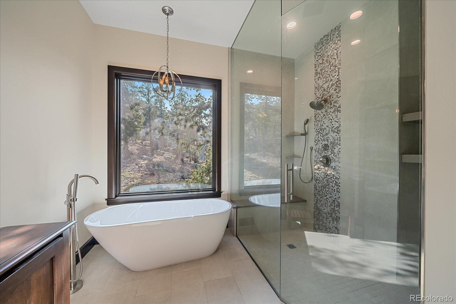 4331 Hilltop Road Evergreen, CO 80439 - Photo 19 of 45 a bathroom with a bathtub and shower