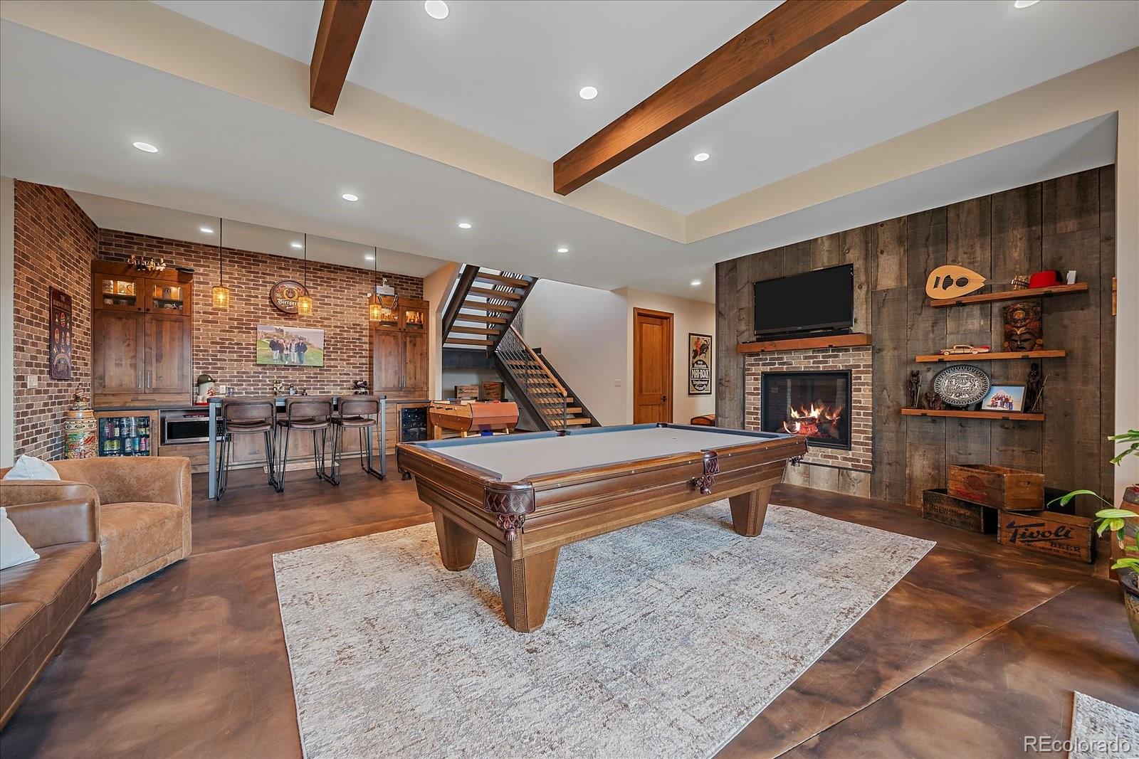 4331 Hilltop Road Evergreen, CO 80439 - Photo 26 of 45 a living room with furniture a pool table and a fireplace