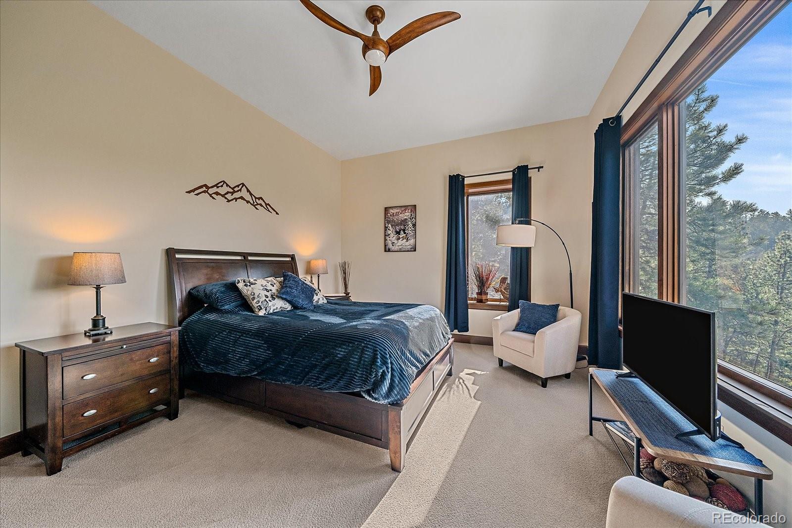 4331 Hilltop Road Evergreen, CO 80439 - Photo 29 of 45 a bedroom with a bed and wooden floor