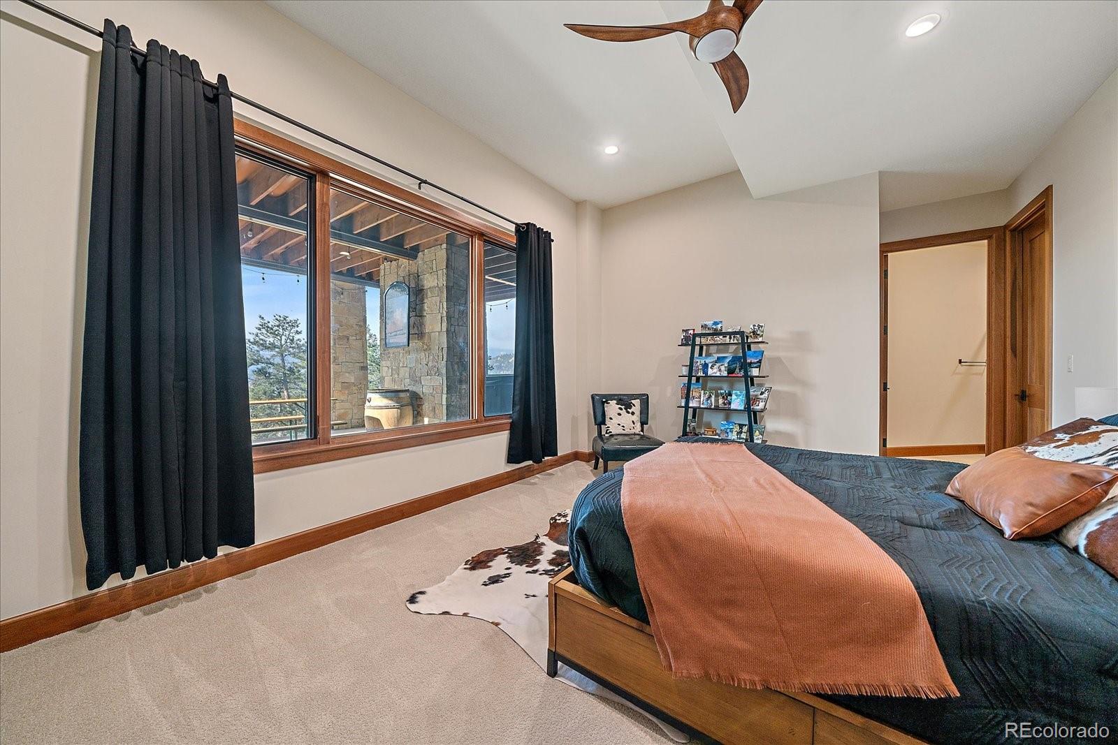 4331 Hilltop Road Evergreen, CO 80439 - Photo 31 of 45 a bedroom with furniture and a large window