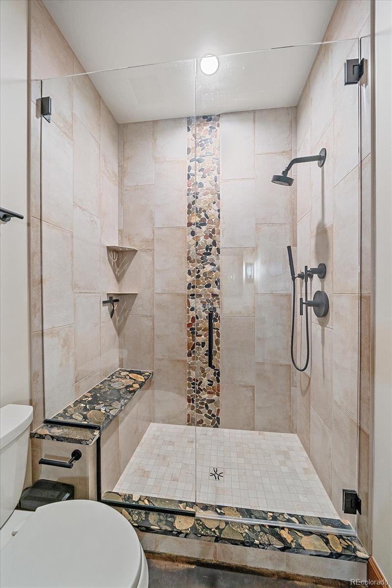 4331 Hilltop Road Evergreen, CO 80439 - Photo 32 of 45 a bathroom with a granite countertop shower