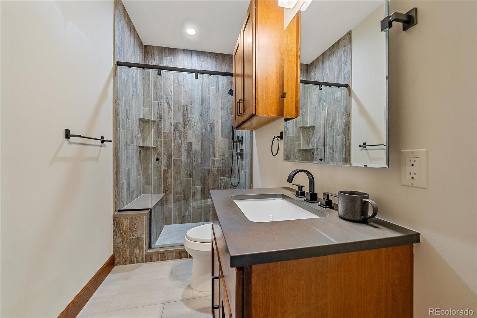 4331 Hilltop Road Evergreen, CO 80439 - Photo 33 of 45 a bathroom with a sink a toilet and shower