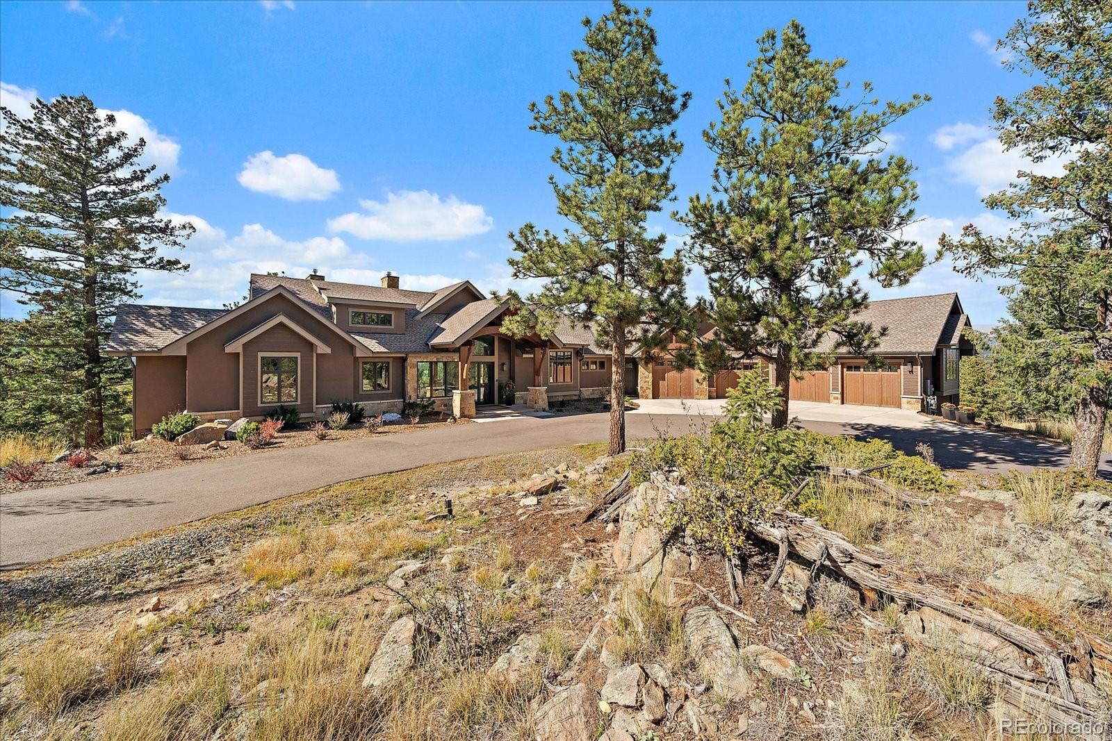 4331 Hilltop Road Evergreen, CO 80439 - Photo 34 of 45 a front view of a house with a yard