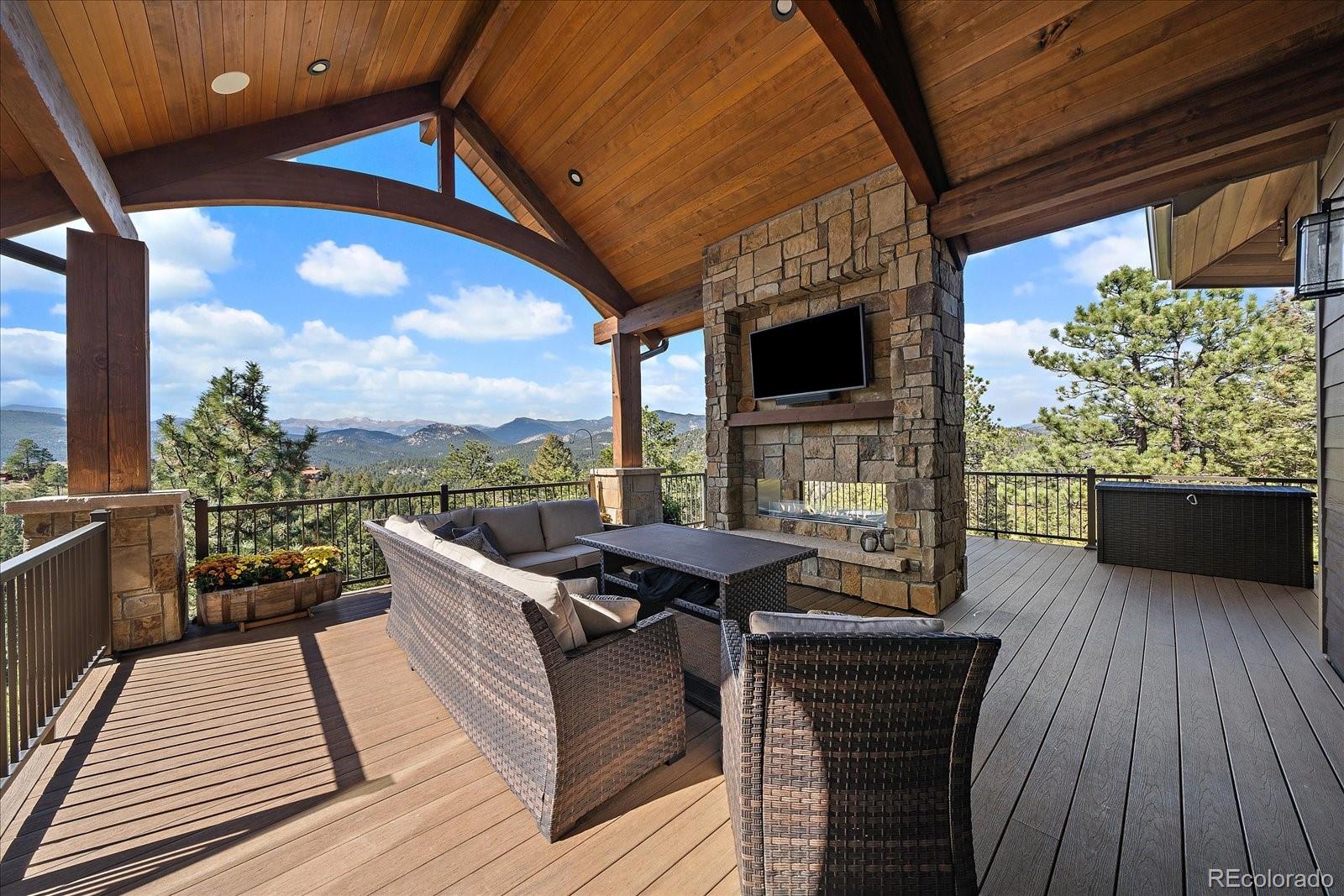 4331 Hilltop Road Evergreen, CO 80439 - Photo 38 of 45 a view of a balcony with furniture and a fireplace