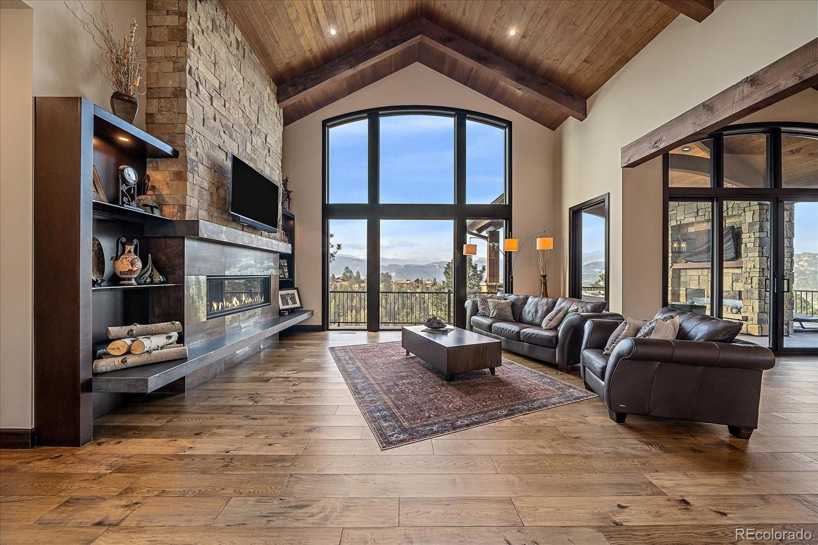 4331 Hilltop Road Evergreen, CO 80439 - Photo 7 of 45 a living room with furniture fireplace and a large window