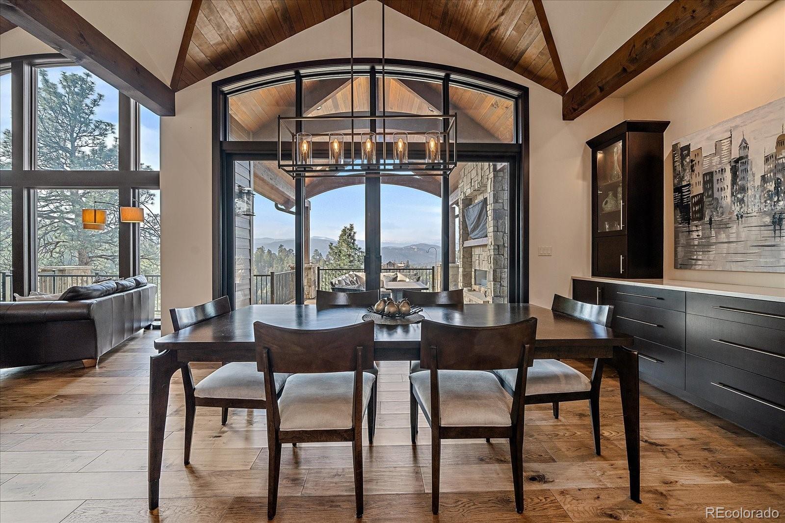 4331 Hilltop Road Evergreen, CO 80439 - Photo 10 of 45 a dining room with furniture a chandelier and wooden floor