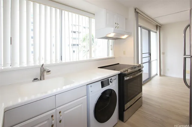 a kitchen with a sink cabinets and a large window