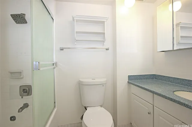 a bathroom with a granite countertop toilet and a sink