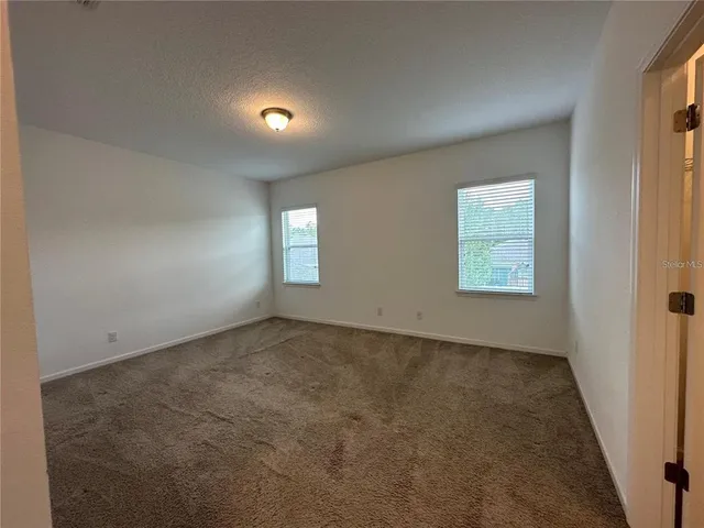 an empty room with a empty space and windows
