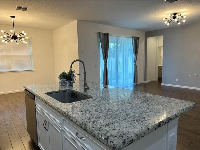 a kitchen with sink and chandelier