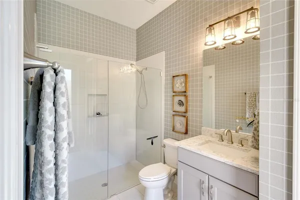 a bathroom with a granite countertop sink toilet and shower