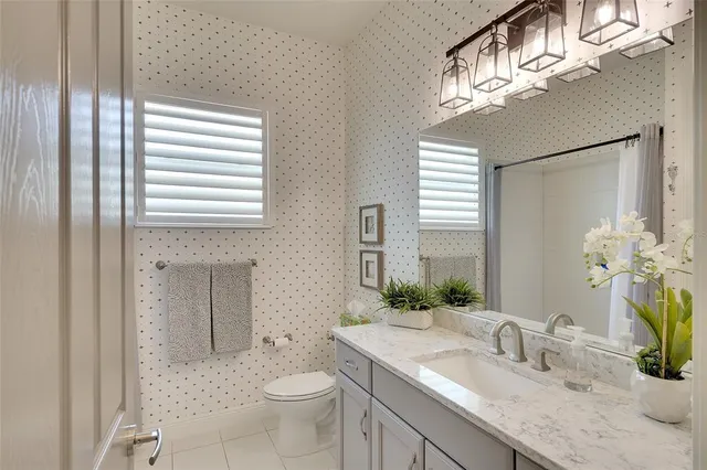 a bathroom with a granite countertop sink a toilet and a mirror