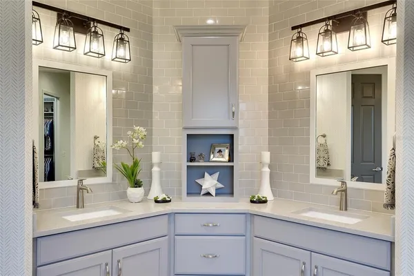 a bathroom with double vanity and a mirror
