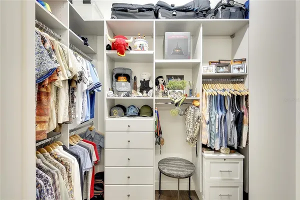 a view of walk in closet with clothes and shoes
