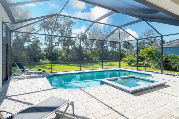 a view of a backyard with swimming pool and sitting area