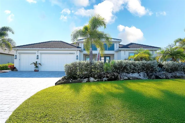 a palm tree sitting in front of a house with a garden