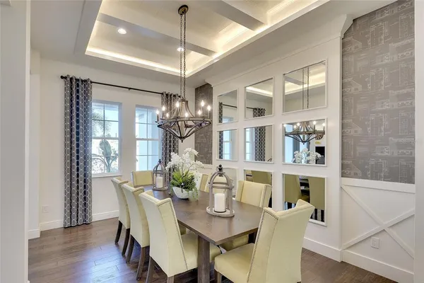 a dining room with furniture a chandelier and wooden floor
