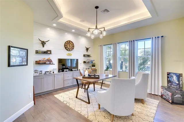 a view of a dining room with furniture a chandelier and wooden floor