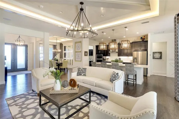 a living room with lots of furniture and kitchen view