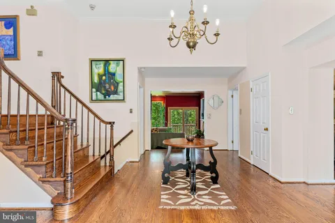 a living room with wooden floor and a dining table