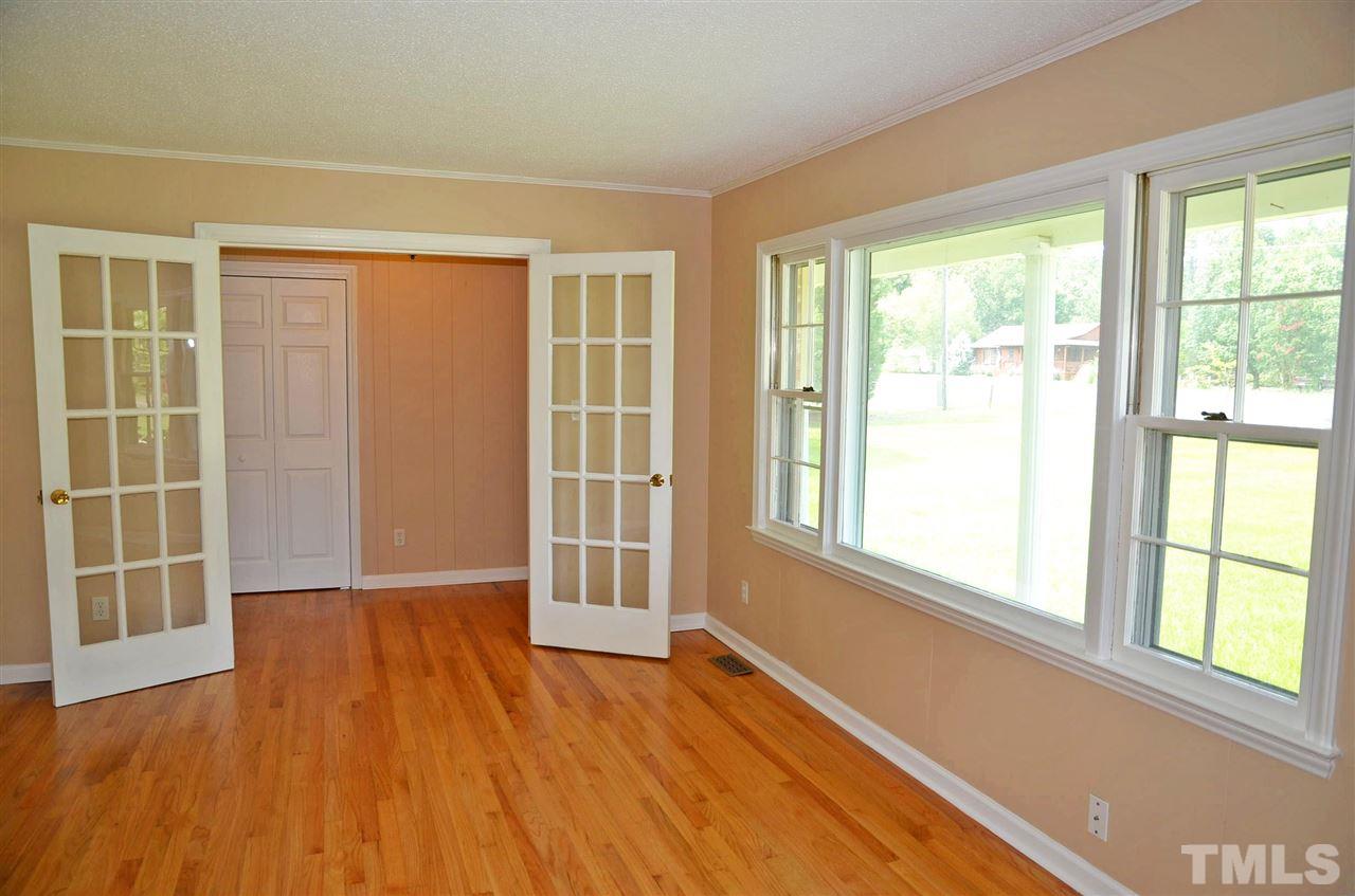 4228 Lassiter Road Wake Forest, NC 27587 - Photo 11 of 20 a view of an empty room with wooden floor and a window