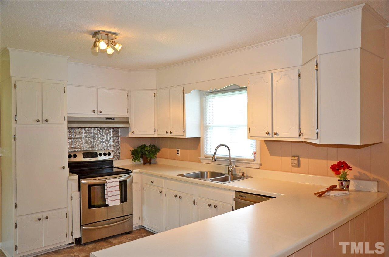 4228 Lassiter Road Wake Forest, NC 27587 - Photo 5 of 20 a kitchen with stainless steel appliances white cabinets and a stove top oven