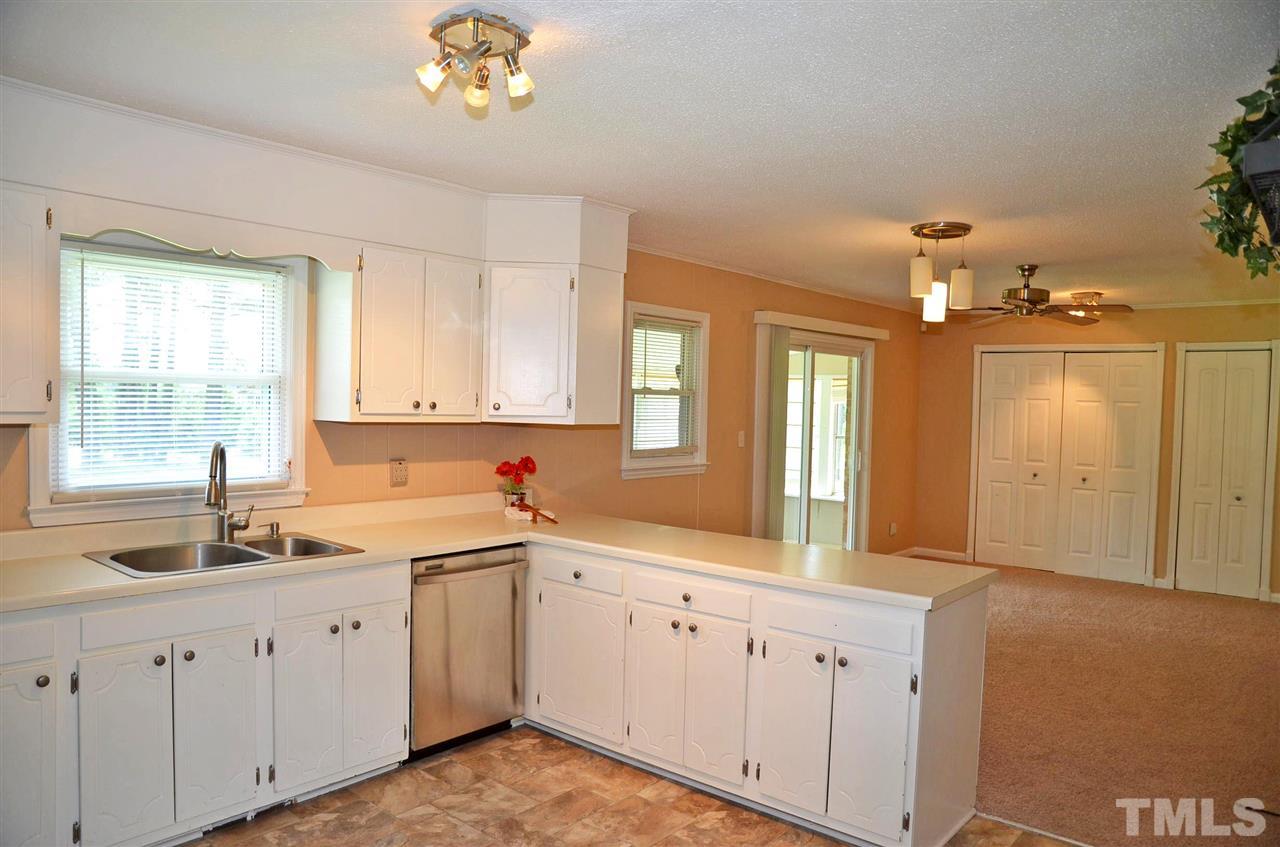 4228 Lassiter Road Wake Forest, NC 27587 - Photo 7 of 20 a large white kitchen with a sink large window and stainless steel appliances