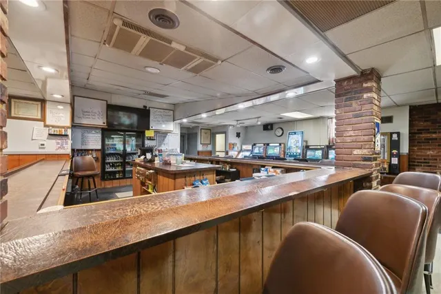 a dining hall with stainless steel appliances granite countertop a dining table and chairs with wooden floor