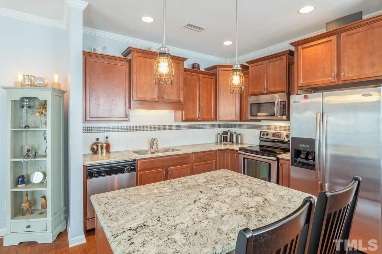 2427 Memory Ridge Drive Raleigh, NC 27606 - Photo 7 of 22 a kitchen with stainless steel appliances granite countertop a stove refrigerator sink and cabinets