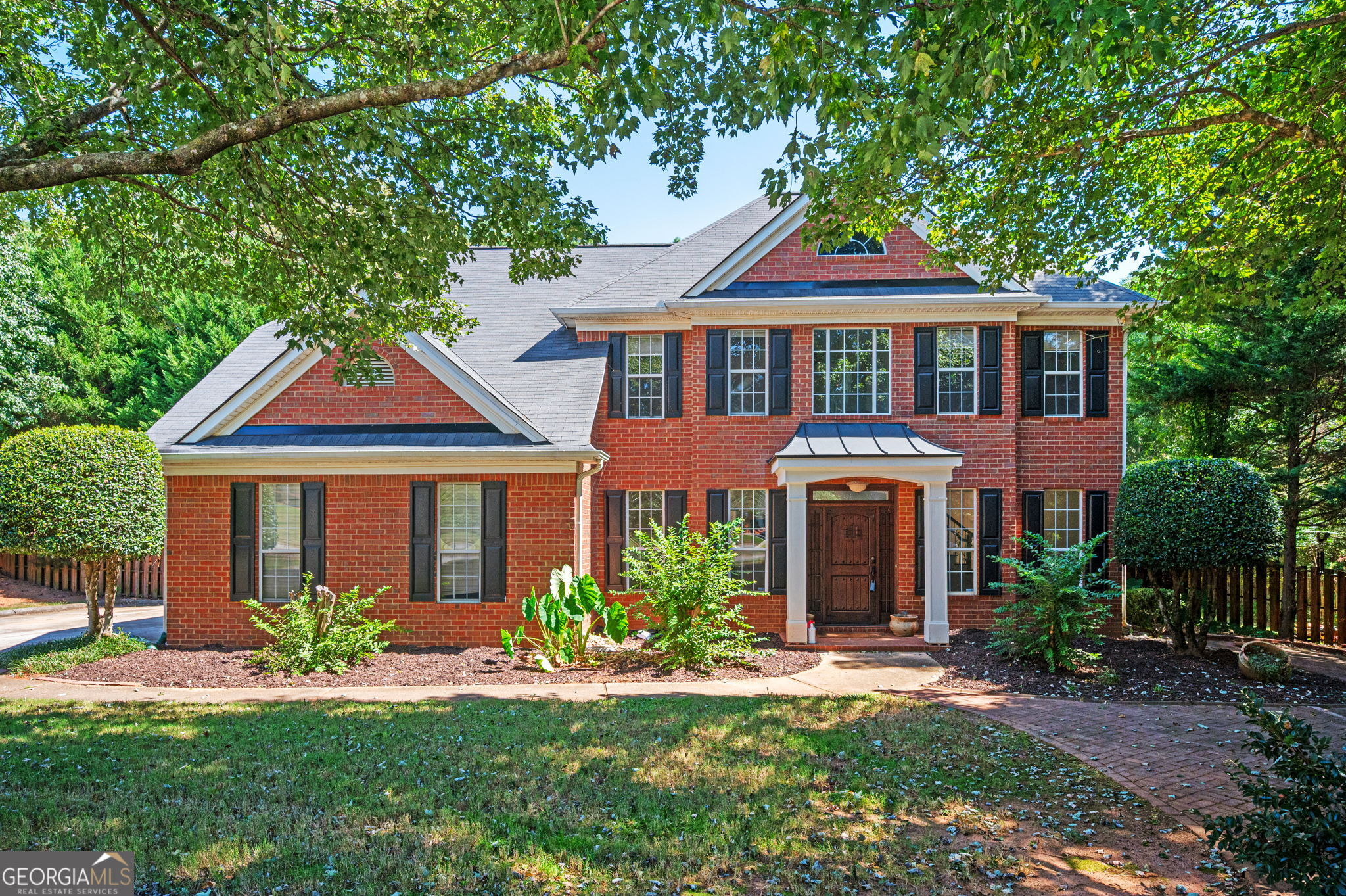 a front view of a house with a garden