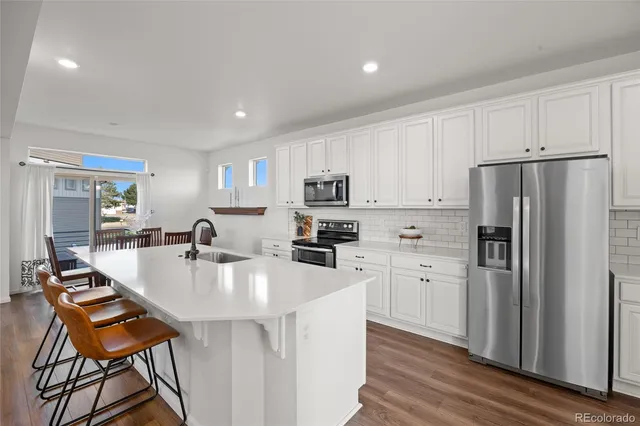 a kitchen with stainless steel appliances granite countertop a table and chairs