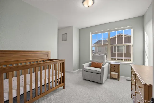 a room with furniture a baby crib and a window