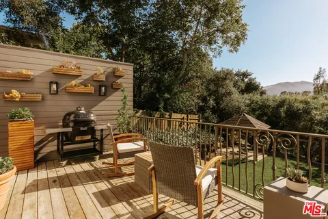 a terrace with outdoor seating and trees