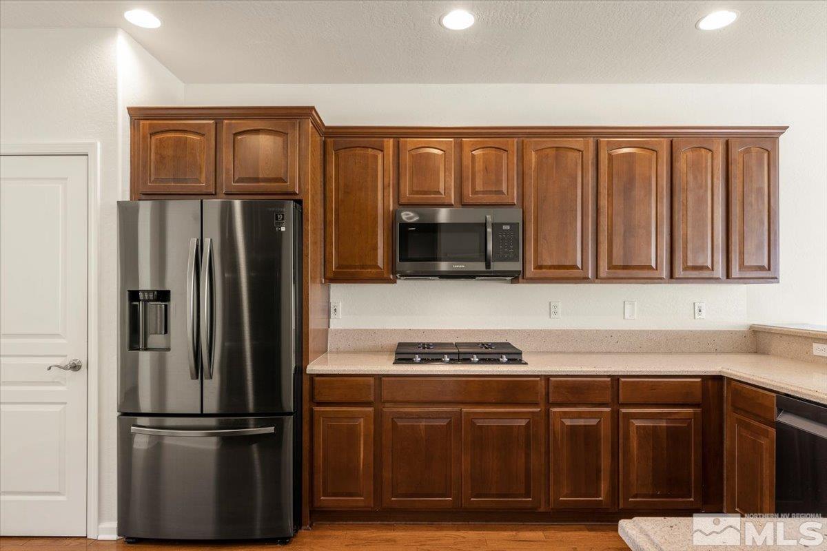 1125 Cliff Park Way Reno, NV 89523 - Photo 11 of 40 a kitchen with granite countertop stainless steel appliances and wooden cabinets