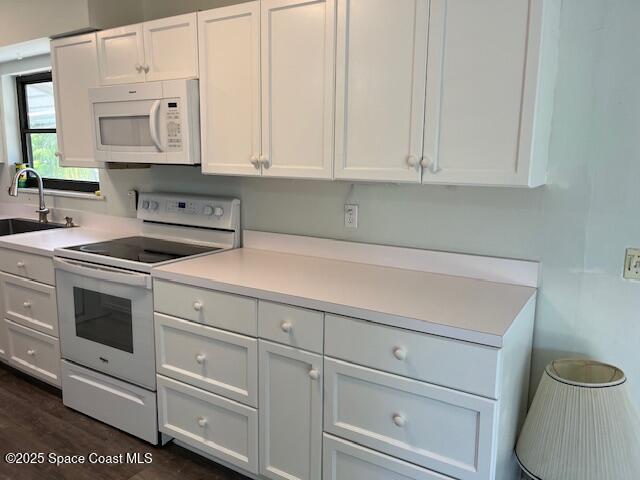 589 Michael Street Sebastian, FL 32958 - Photo 17 of 36 a kitchen with white cabinets and white appliances
