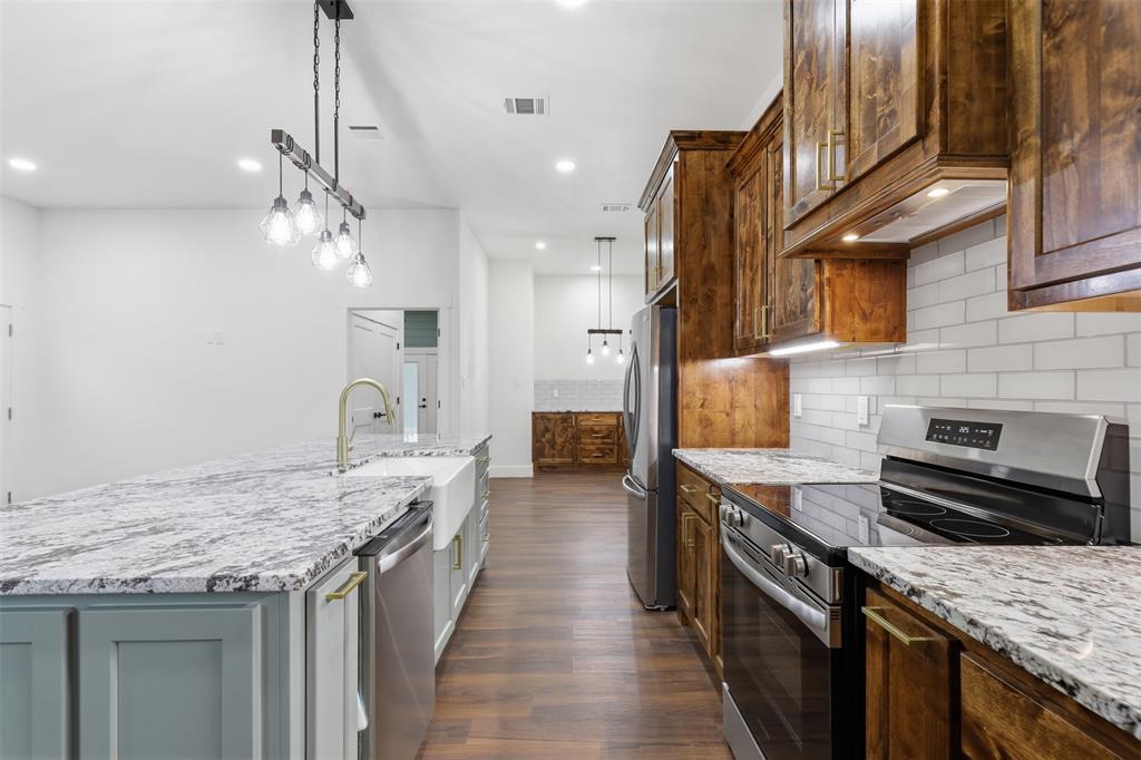 1413 Ridgeview Circle Granbury, TX 76048 - Photo 6 of 35 Kitchen featuring a granite island with an undermount farmhouse sink, stainless steel dishwasher, and gold-finish faucet
