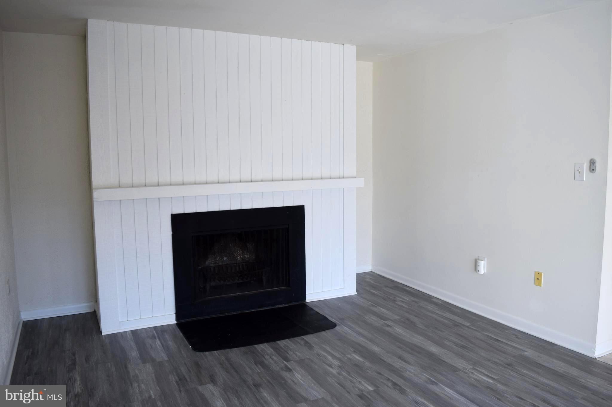 10566 Twin Rivers Road, Unit F1 Columbia, MD 21044 - Photo 12 of 44 a room with a fireplace and wooden floor