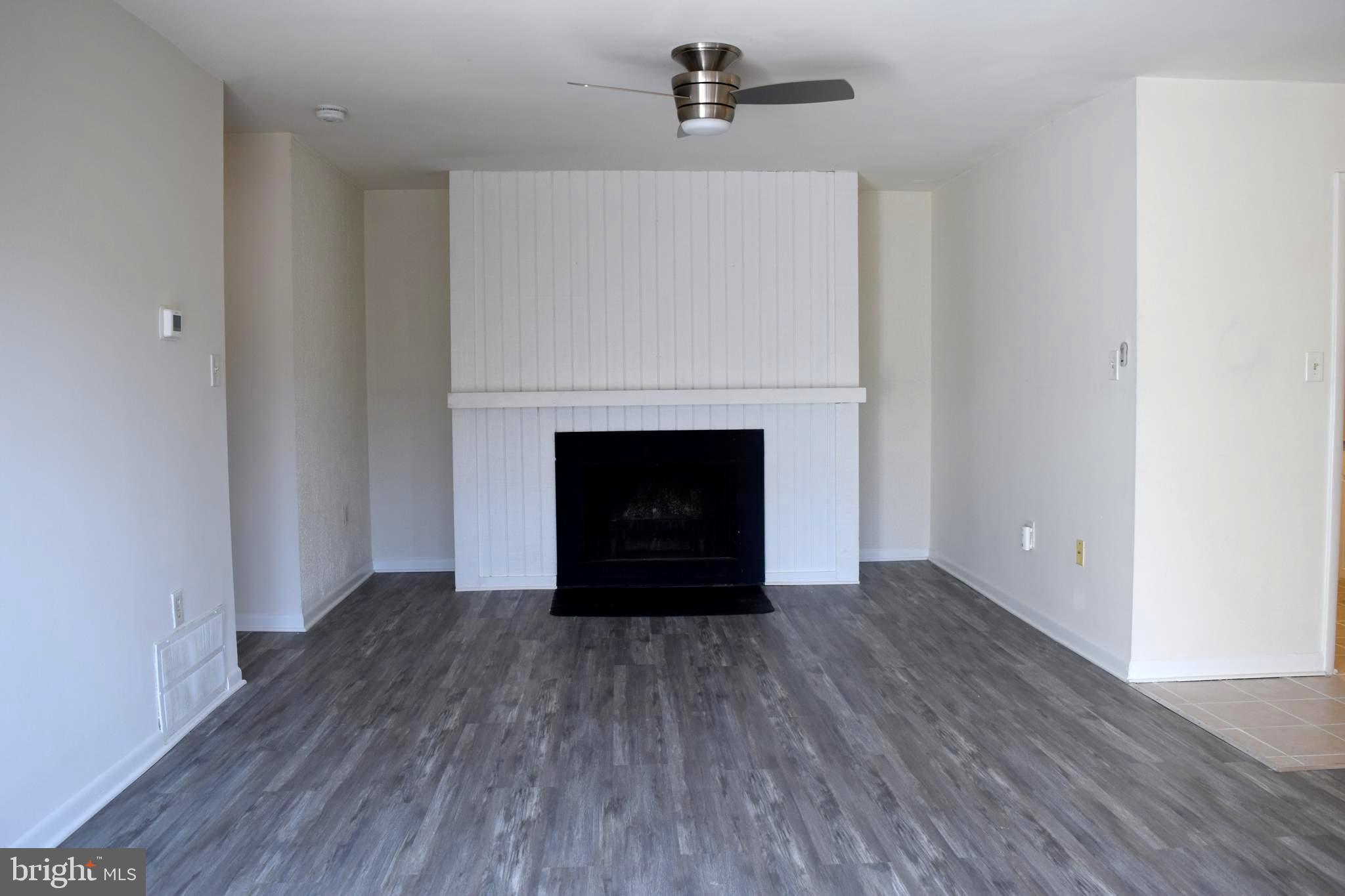 10566 Twin Rivers Road, Unit F1 Columbia, MD 21044 - Photo 13 of 44 a room with a fireplace and wooden floor