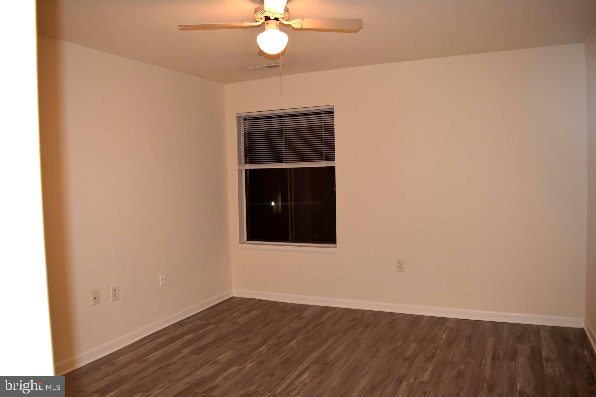 10566 Twin Rivers Road, Unit F1 Columbia, MD 21044 - Photo 20 of 44 an empty room with wooden floor closet and fan
