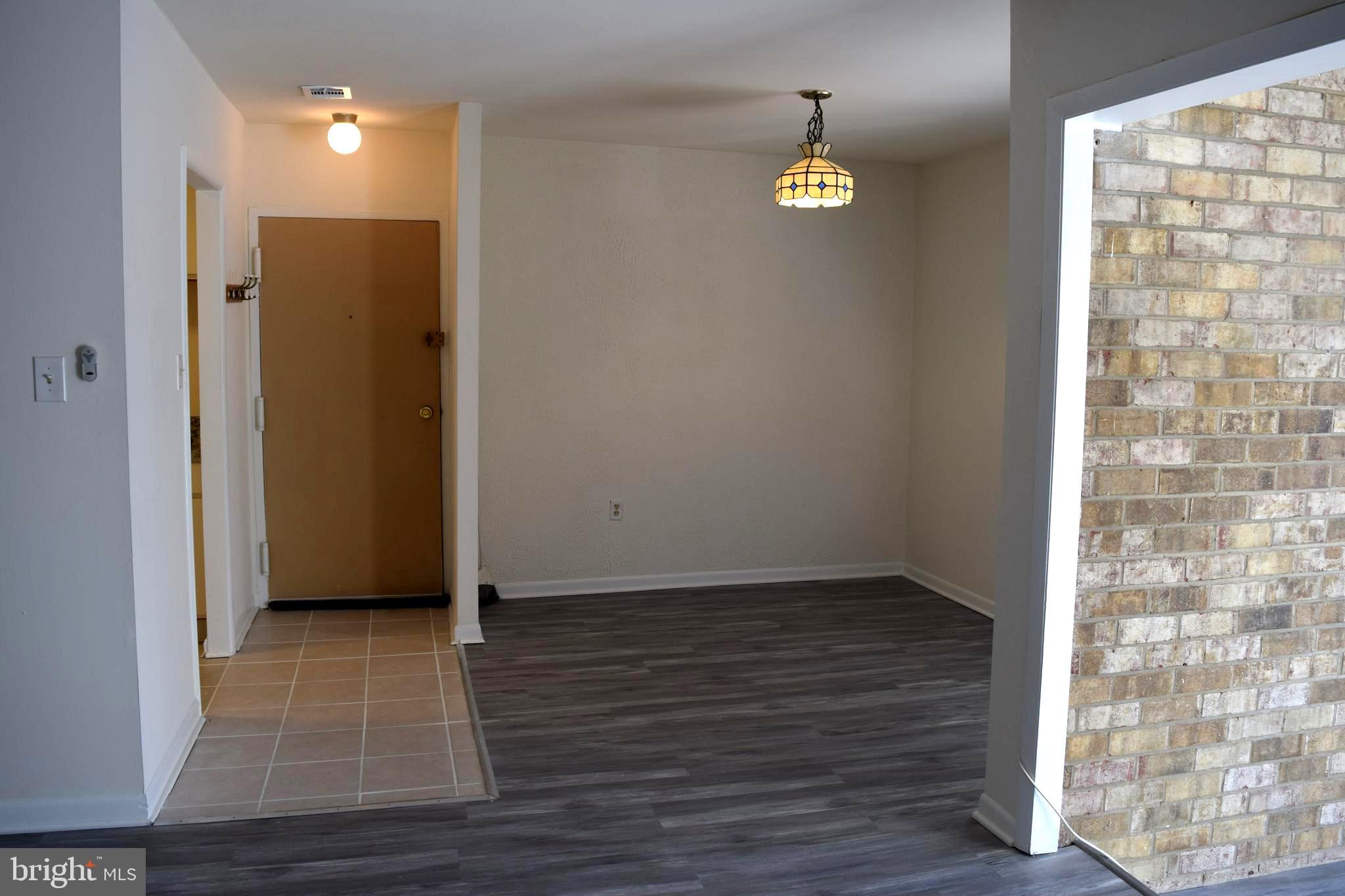 10566 Twin Rivers Road, Unit F1 Columbia, MD 21044 - Photo 2 of 44 a view of an empty room with wooden floor and a window