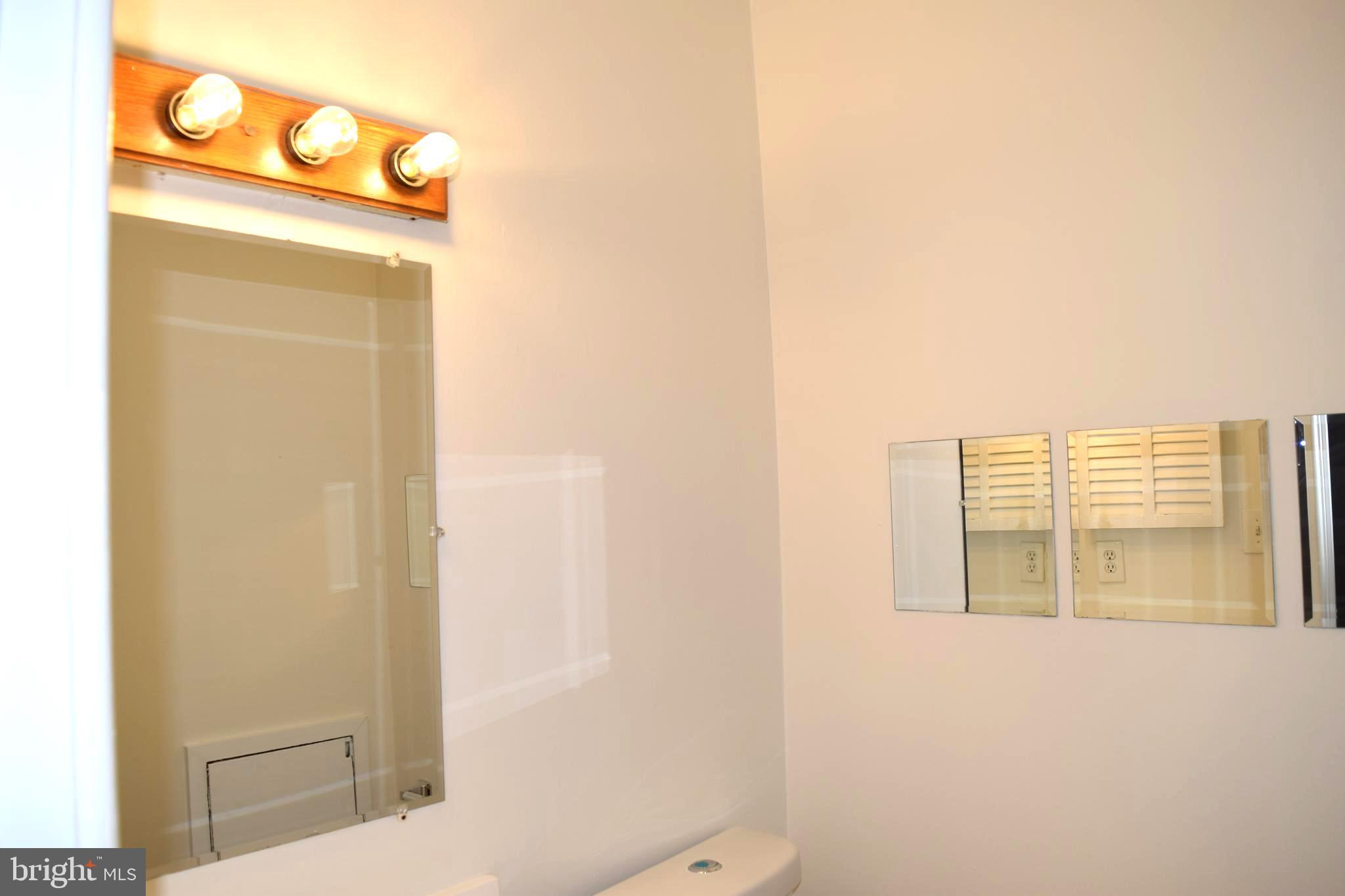 10566 Twin Rivers Road, Unit F1 Columbia, MD 21044 - Photo 28 of 44 a bathroom with a toilet sink and mirror