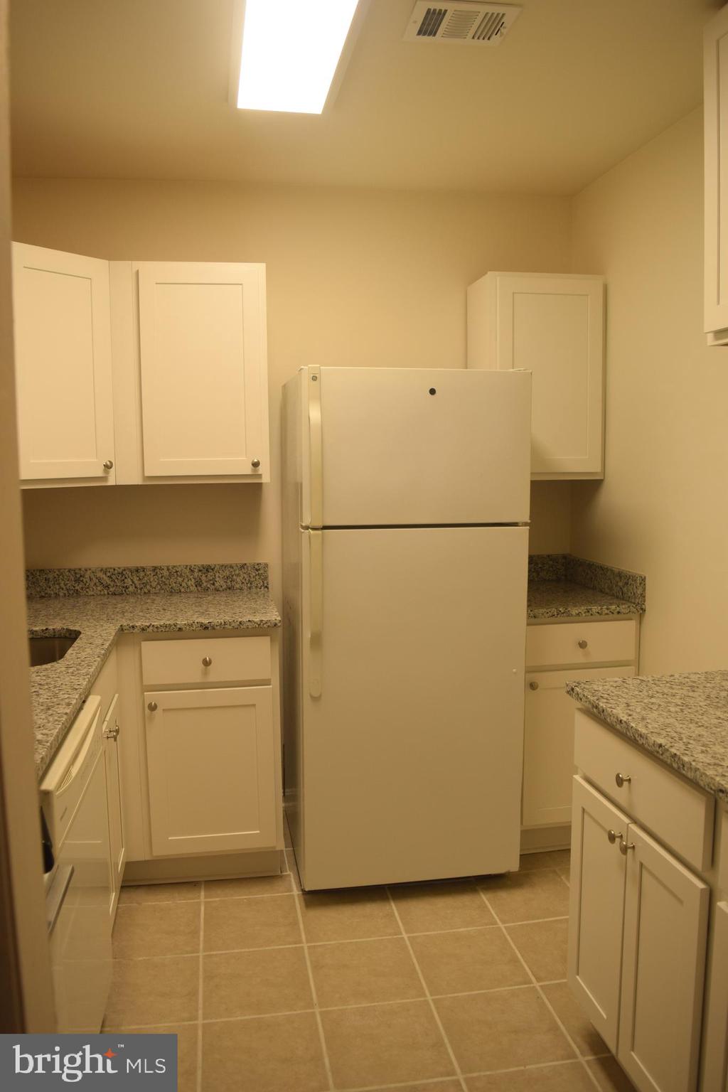 10566 Twin Rivers Road, Unit F1 Columbia, MD 21044 - Photo 32 of 44 a white refrigerator freezer sitting in a kitchen