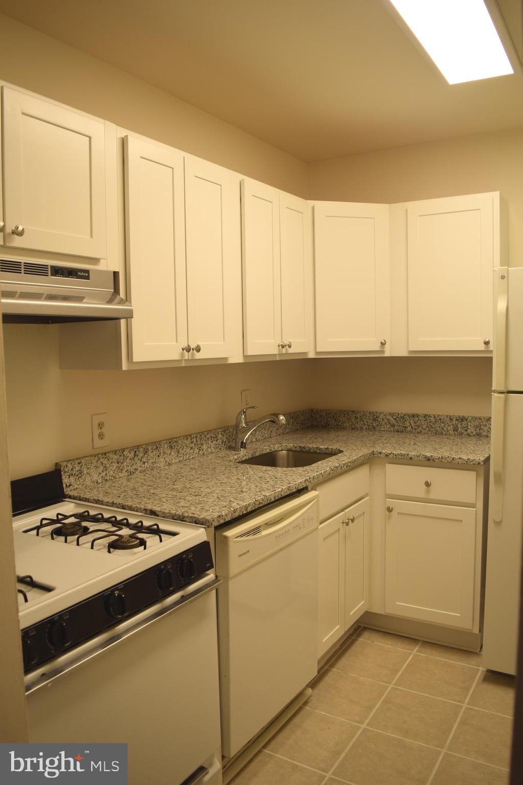10566 Twin Rivers Road, Unit F1 Columbia, MD 21044 - Photo 35 of 44 a kitchen with stainless steel appliances granite countertop a stove and a sink