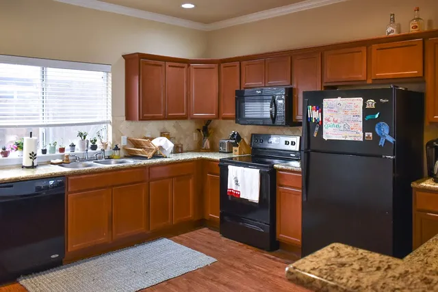 a kitchen with stainless steel appliances granite countertop a refrigerator stove top oven a sink and dishwasher