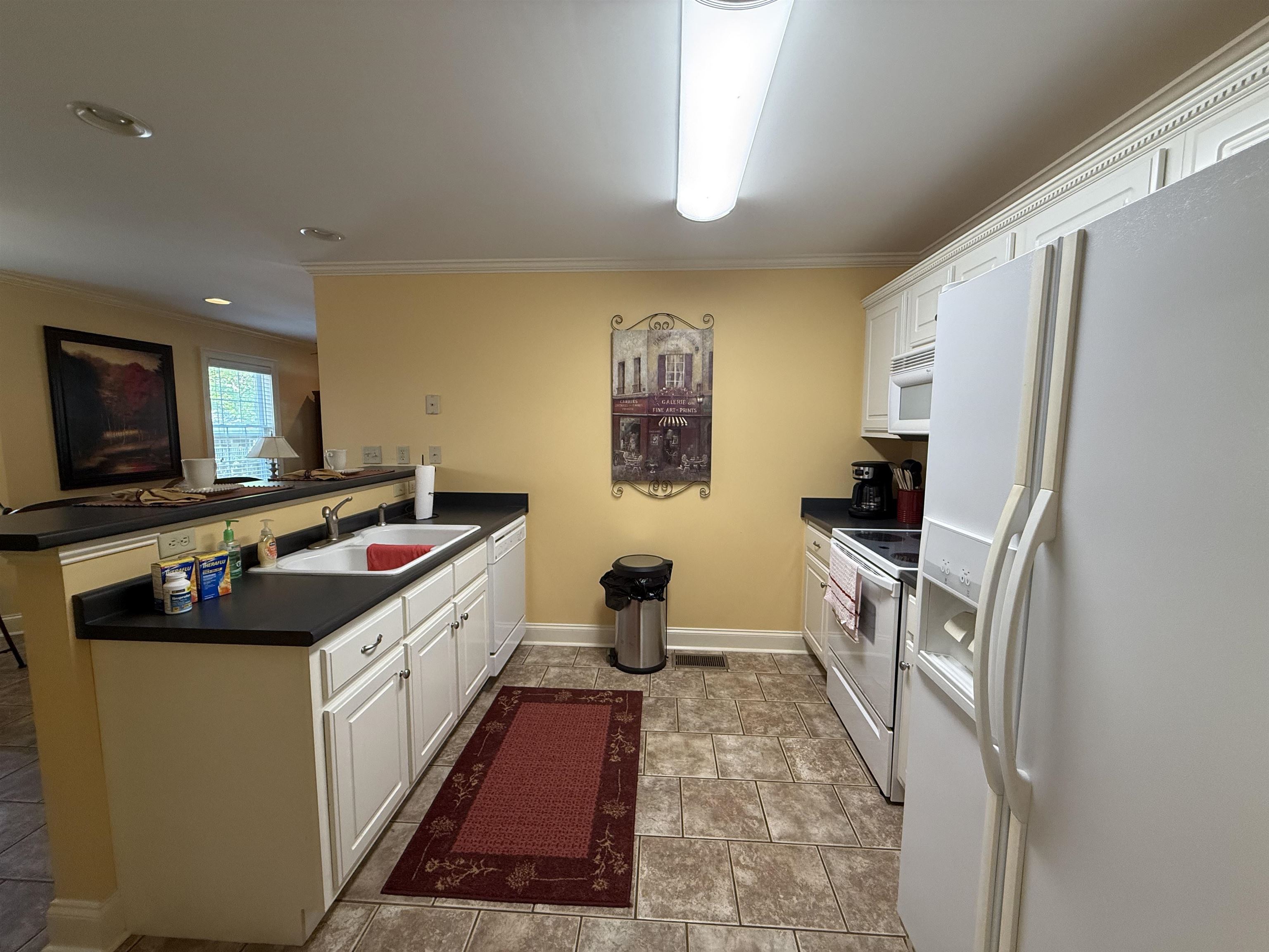 14 Patsy Path Iuka, MS 38852 - Photo 11 of 33 Kitchen with white cabinetry, a sink, dark countertops, white appliances, and a peninsula