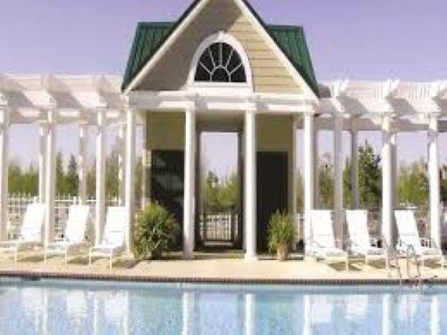 Community pool featuring an outdoor structure, a pergola, and an exterior structure