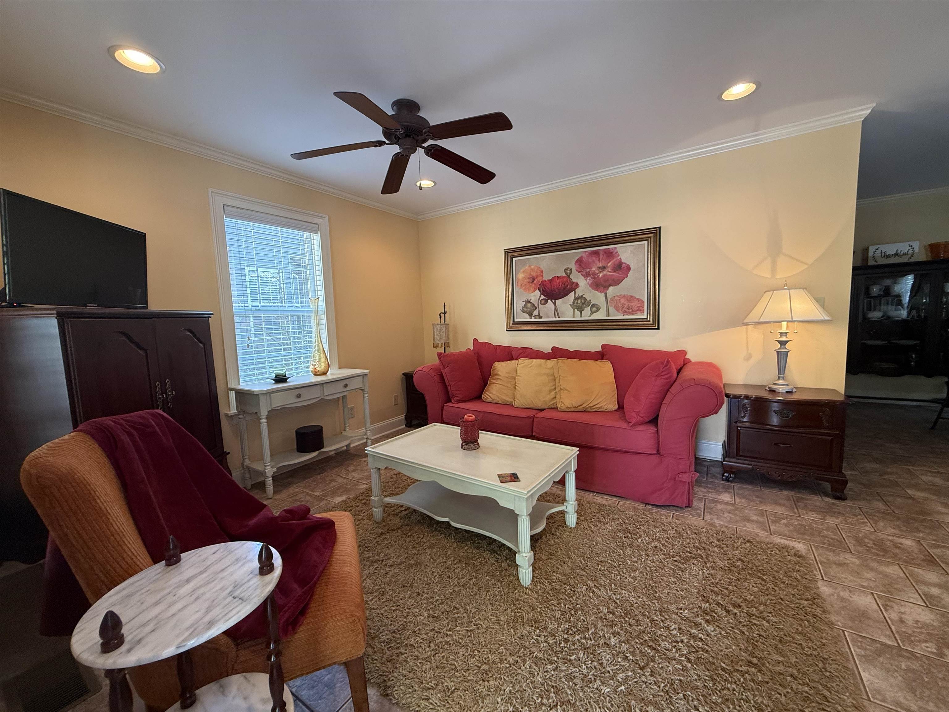 Living area featuring crown molding, recessed lighting, ceiling fan, and stone finish floor