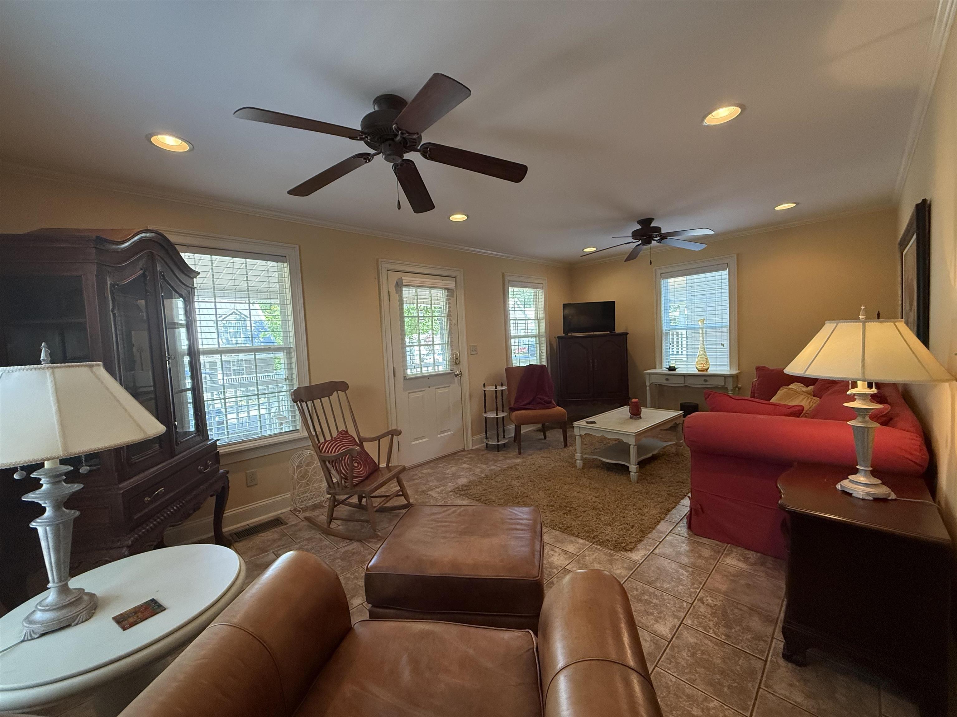 Tiled living room featuring baseboards, recessed lighting, ornamental molding, and a ceiling fan